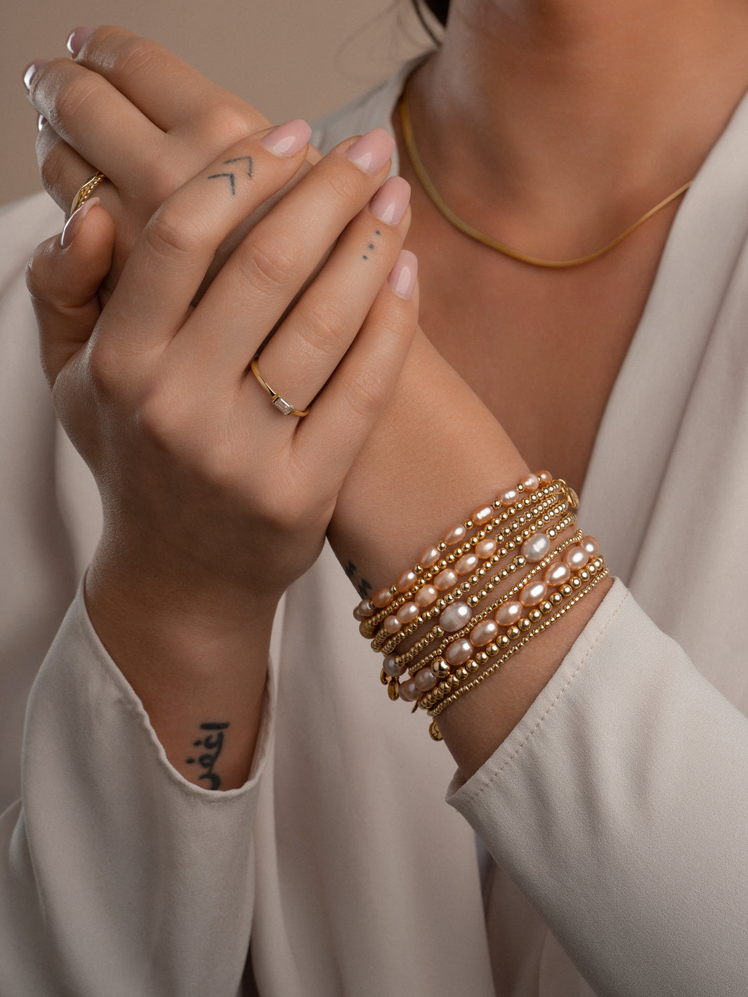 Dames armband met echte peachkleurige parels en goudkleurige accenten